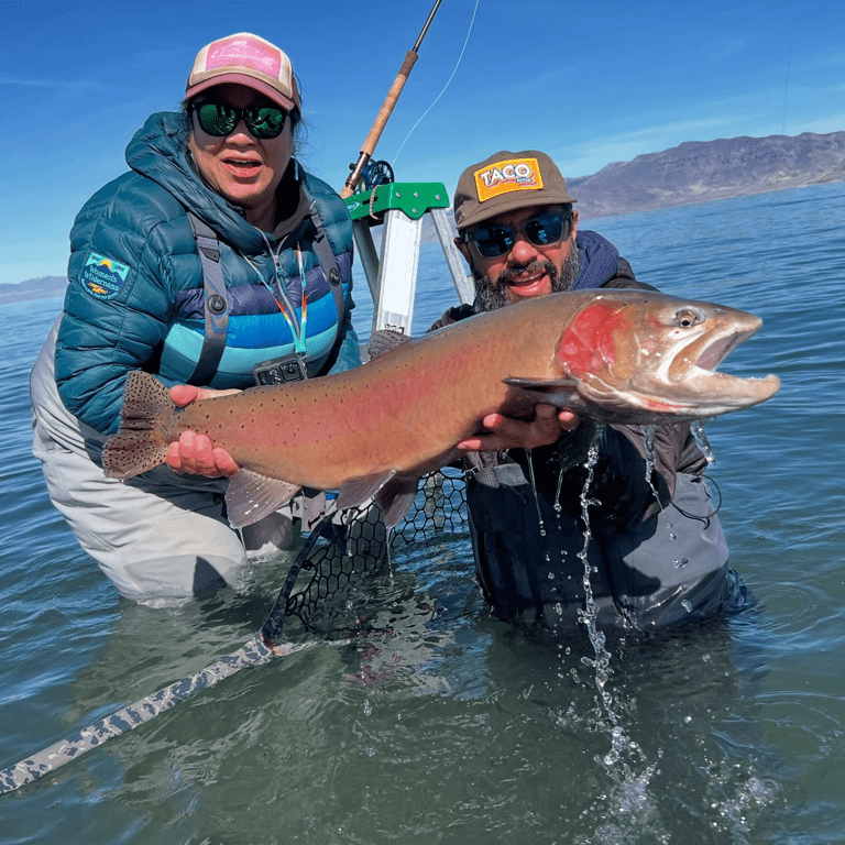 Two anglers holding a large cutthroat trout in Pyramid Lake, Nevada during a guided fly fishing trip with Taco Fly Co