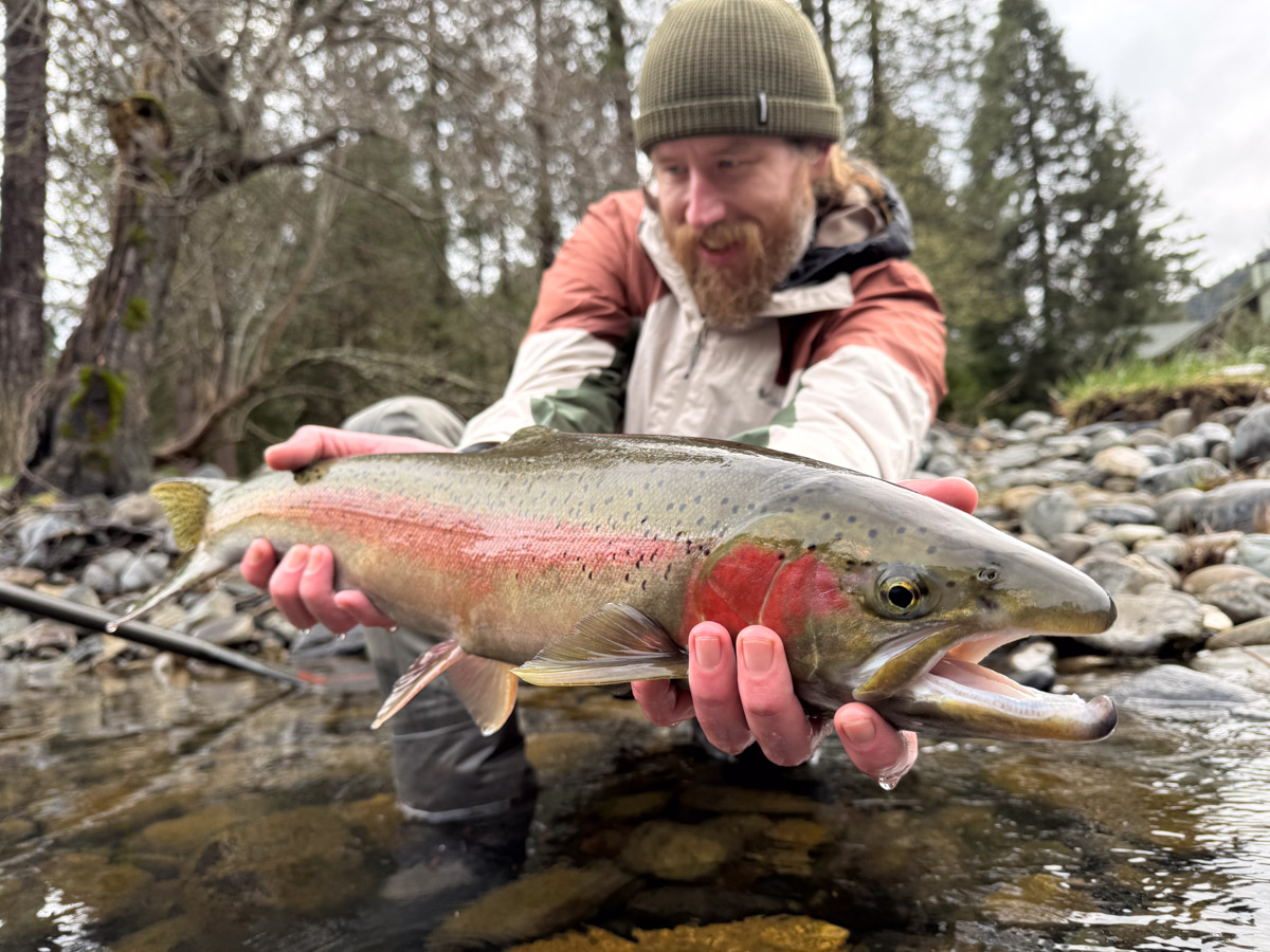 Man holding a big trout on a river