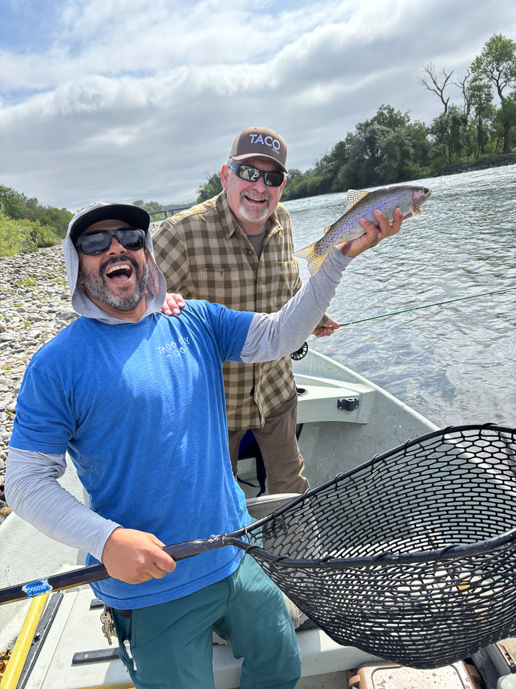 Rainbow trout in a guides hand on a river
