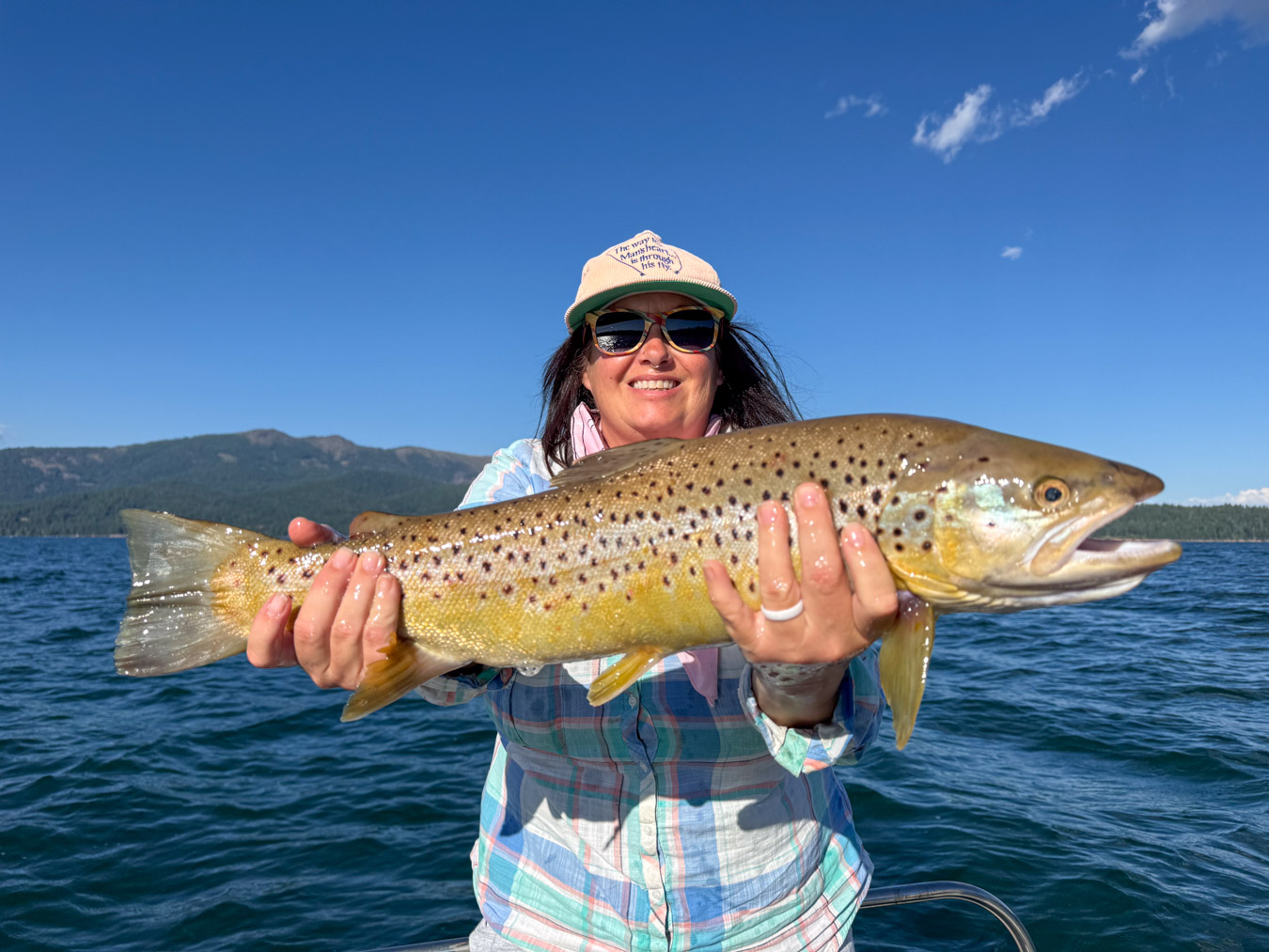 Woman holding a big brown trout caught during the lake almanor hex hatch