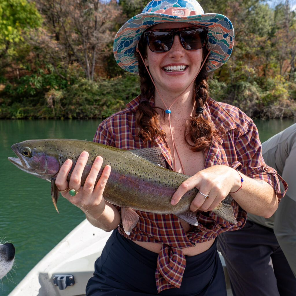Woman holding a rainbow trout caught on the fly